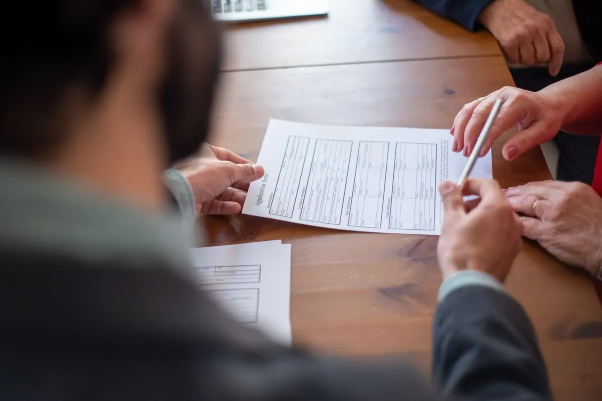 Close-up of people reviewing documents together during a professional meeting